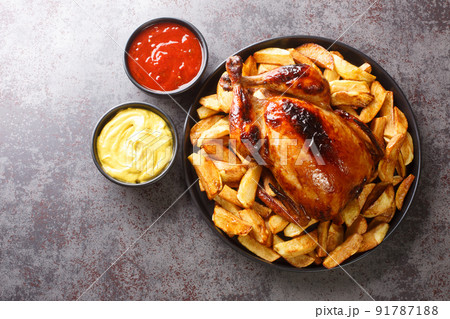 Peruvian Pollo a la Brasa chicken with fried potatoes and sauces close-up in a plate. horizontal top view 91787188