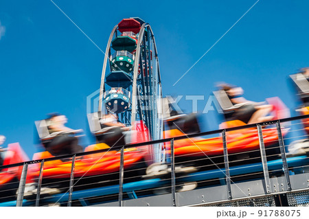 Ferris wheel and roller coaster in motion in amusement park Ferris wheel and roller coaster in motion in amusement park 91788075