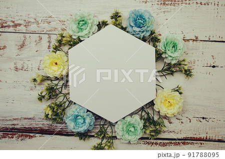 Frame of flowers with paper card for text on wooden background 91788095
