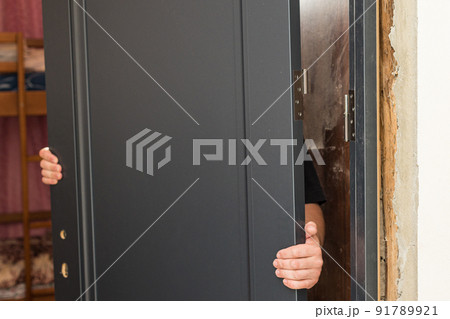 The craftsman installs the door leaf on the hinged hinge. The craftsman installs the door leaf on the hinged hinge. 91789921