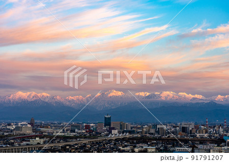呉羽山展望台から望む立山連峰と北陸新幹線の高架橋が走る富山市の中心部 91791207