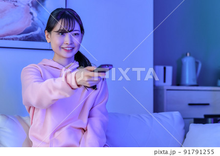 深夜にテレビを見る若い女性　笑顔 91791255