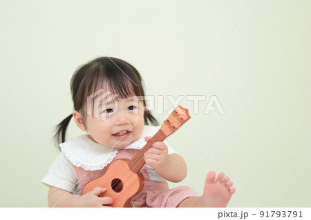 ギターのおもちゃで遊ぶ1歳の女の子 91793791