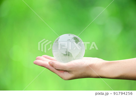 Crystal globe in hand with green background, concept for eco friendly business, green energy and climate change. 91794256