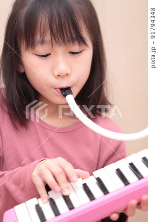 鍵盤ハーモニカを演奏する女の子 91794348