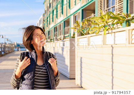 おしゃれな建物の周りを散歩する女性、上半身 91794357