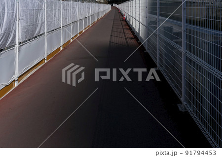 工事中のフェンスが白く光っている長い歩道橋・北区堀船 91794453