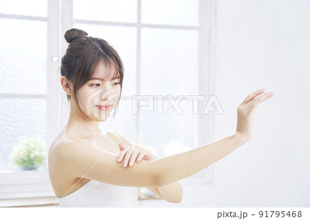 リビングで腕のケアをする女性 リビングで腕のケアをする女性 91795468