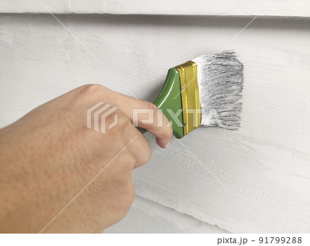 Hand holding brush painting wall Hand holding brush painting wall 91799288