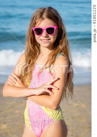 Fashion cute young girl posing on the beach in a summer swimsuit. 91801220