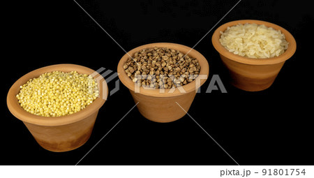 A set of cereals for preparing porridge for breakfast. Cereals in clay bowls: millet, rice, buckwheat on a black background A set of cereals for preparing porridge for breakfast. Cereals in clay bowls: millet, rice, buckwheat on a black background 91801754