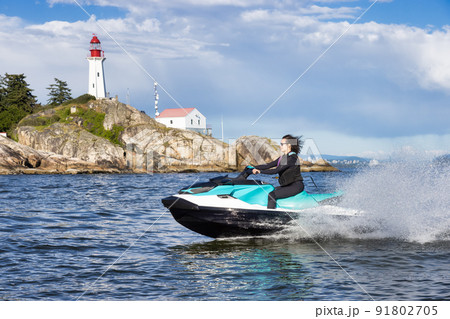 Adventurous Caucasian Woman on Sea-Doo riding in the Ocean Adventurous Caucasian Woman on Sea-Doo riding in the Ocean 91802705