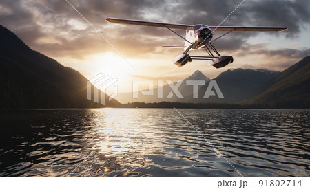 Seaplane flying over a Lake, trees and mountains in Canadian Landscape. 91802714