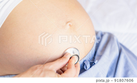 Doctor consultation pregnant woman. Medical clinic for pregnancy consultant. Doctor examining pregnancy woman belly holding stethoscope. Concept maternity, pregnancy, childbirth. 91807606