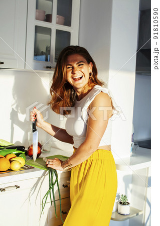 real cheerful lady on kitchen preparing dinner, lifestyle people concept close up 91810590