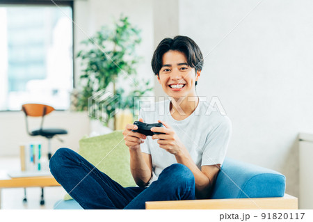 リビングでゲームをする若い男性 91820117