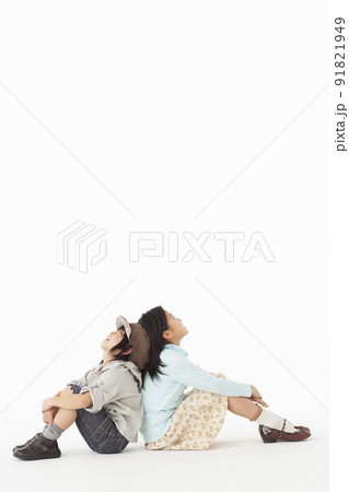 座って上を見上げる姉弟 91821949