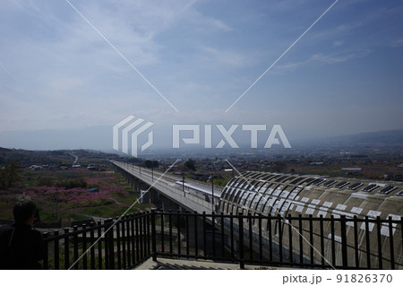 山梨県笛吹市の花鳥山展望台から見るリニア実験線と桃の花の春の風景 91826370