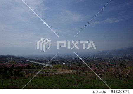 山梨県笛吹市の花鳥山展望台から見るリニア実験線と桃の花の春の風景 91826372