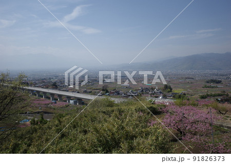 山梨県笛吹市の花鳥山展望台から見るリニア実験線と桃の花の春の風景 91826373