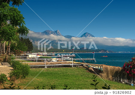 View of the path and the bridge in a green garden with green trees along the embankment in Kemer, Turkey. View of the path and the bridge in a green garden with green trees along the embankment in Kemer, Turkey. 91826902