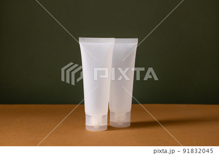 A set of empty white tube bottles with cosmetics on brown and green background . Eco-friendly cosmetics. The concept of cosmetic skin and body care, treatment, youth preservation. A set of empty white tube bottles with cosmetics on brown and green background . Eco-friendly cosmetics. The concept of cosmetic skin and body care, treatment, youth preservation. 91832045