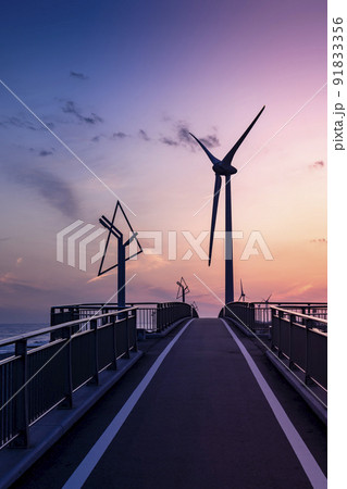 夕暮れ時の静岡県掛川市の菊川河口にある自転車道の潮騒橋と風力発電の風車 夕暮れ時の静岡県掛川市の菊川河口にある自転車道の潮騒橋と風力発電の風車 91833356
