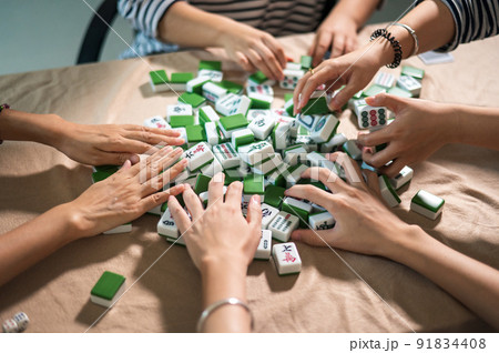Women playing mahjong traditional Chinese board game at home 91834408