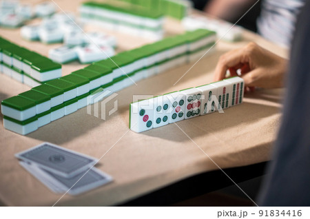 Women playing mahjong traditional Chinese board game at home Women playing mahjong traditional Chinese board game at home 91834416