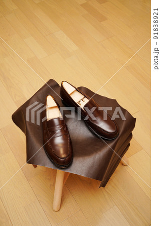 スツール上に置いたシンプルなダークブラウン色のコインローファー スツール上に置いたシンプルなダークブラウン色のコインローファー 91838921