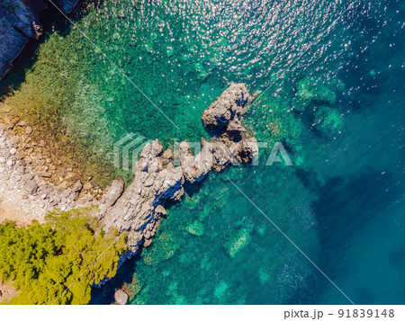 Picturesque sea Adriatic coast of Montenegro. Turquoise Mediteran sea and rocky shore with evergreen coniferous trees. Wonderful summer landscape. Drone Picturesque sea Adriatic coast of Montenegro. Turquoise Mediteran sea and rocky shore with evergreen coniferous trees. Wonderful summer landscape. Drone 91839148