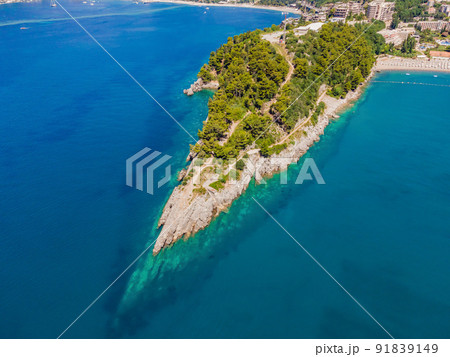 Picturesque sea Adriatic coast of Montenegro. Turquoise Mediteran sea and rocky shore with evergreen coniferous trees. Wonderful summer landscape. Drone Picturesque sea Adriatic coast of Montenegro. Turquoise Mediteran sea and rocky shore with evergreen coniferous trees. Wonderful summer landscape. Drone 91839149