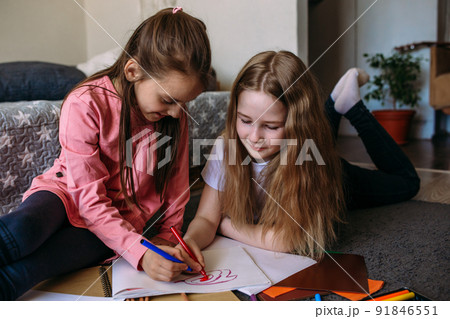 Two girls friends play at home, draw with pencils and felt-tip pens and have fun Two girls friends play at home, draw with pencils and felt-tip pens and have fun 91846551