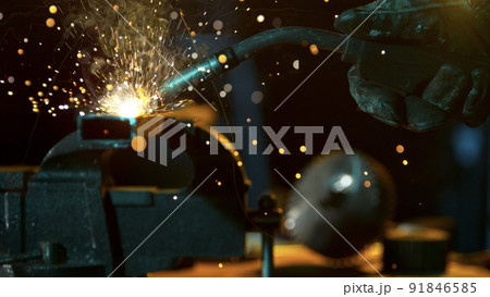 Freeze Motion of Working Welder in Workshop. Detail shot, low depth of focus. 91846585