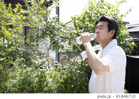 ペットボトルの水を飲んで水分補給をする男性 ペットボトルの水を飲んで水分補給をする男性 91846710