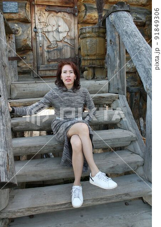 A red-haired girl sitting on the porch of Baba Yaga's hut. A red-haired girl sitting on the porch of Baba Yaga's hut. 91849306
