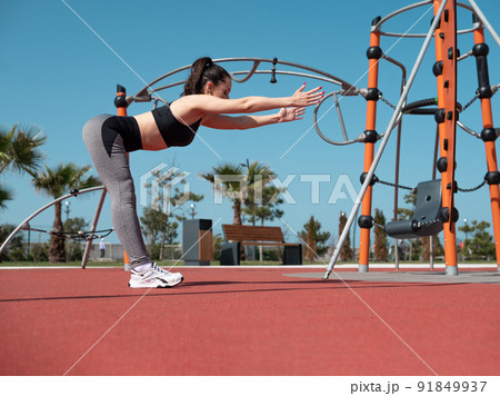 a sporty girl does fitness on a sports field in the summer outdoors a sporty girl does fitness on a sports field in the summer outdoors 91849937