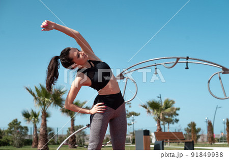 a sporty girl does fitness on a sports field in the summer outdoors a sporty girl does fitness on a sports field in the summer outdoors 91849938