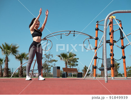 a sporty girl does fitness on a sports field in the summer outdoors a sporty girl does fitness on a sports field in the summer outdoors 91849939
