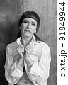 A sensual portrait of a girl with an emotional face and sensual eyes in a white shirt. 91849944