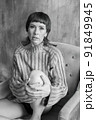 A girl in a sweater sitting in an armchair. The Black and White Theme 91849945