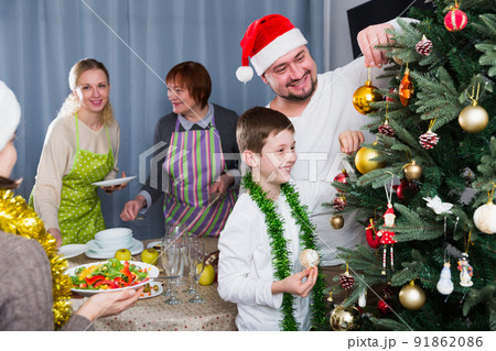 Smiling boy decorating Christmas tree with father Smiling boy decorating Christmas tree with father 91862086