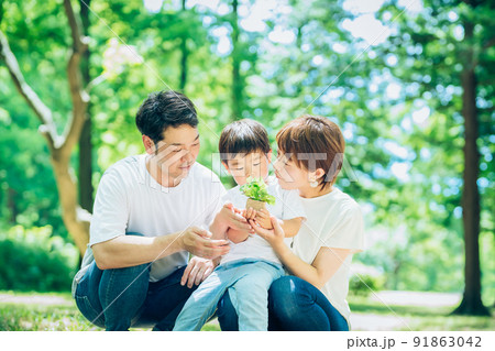 森の中で、小さな鉢植えを持つ家族 森の中で、小さな鉢植えを持つ家族 91863042