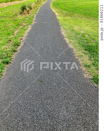 芝生の間を走るアスファルトのまっすぐな一本の道 芝生の間を走るアスファルトのまっすぐな一本の道 91866211