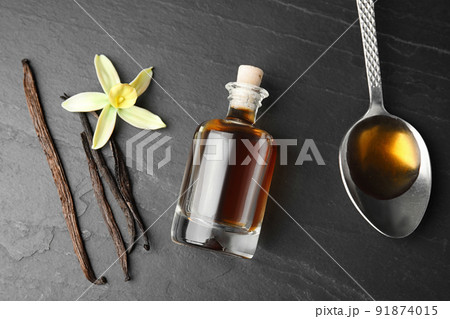 Flat lay composition with vanilla extract on black table Flat lay composition with vanilla extract on black table 91874015