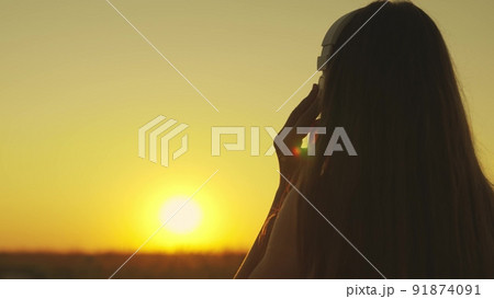 young girl runs across field sunset headphones. silhouette girl rays sunlight listens music. healthy image women health. morning run outdoors cardio. exercises weight loss. long-haired sun girl. 91874091