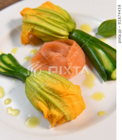 Plate with fried zucchini flowers with a slice of smoked salmon 91874459