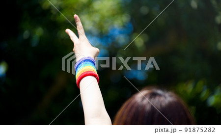 リストバンドを付けた手でピースサインをする 91875282