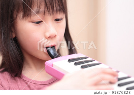 鍵盤ハーモニカを演奏する女の子 91876828
