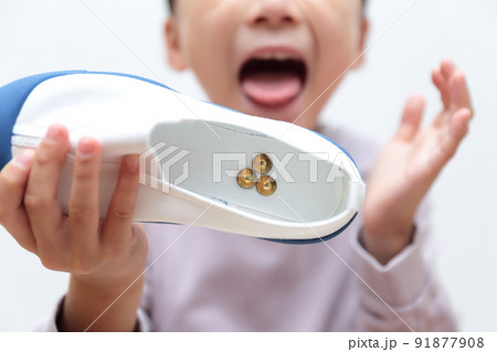 上履きに画鋲が入っていてショックを受ける小学生の女の子 91877908
